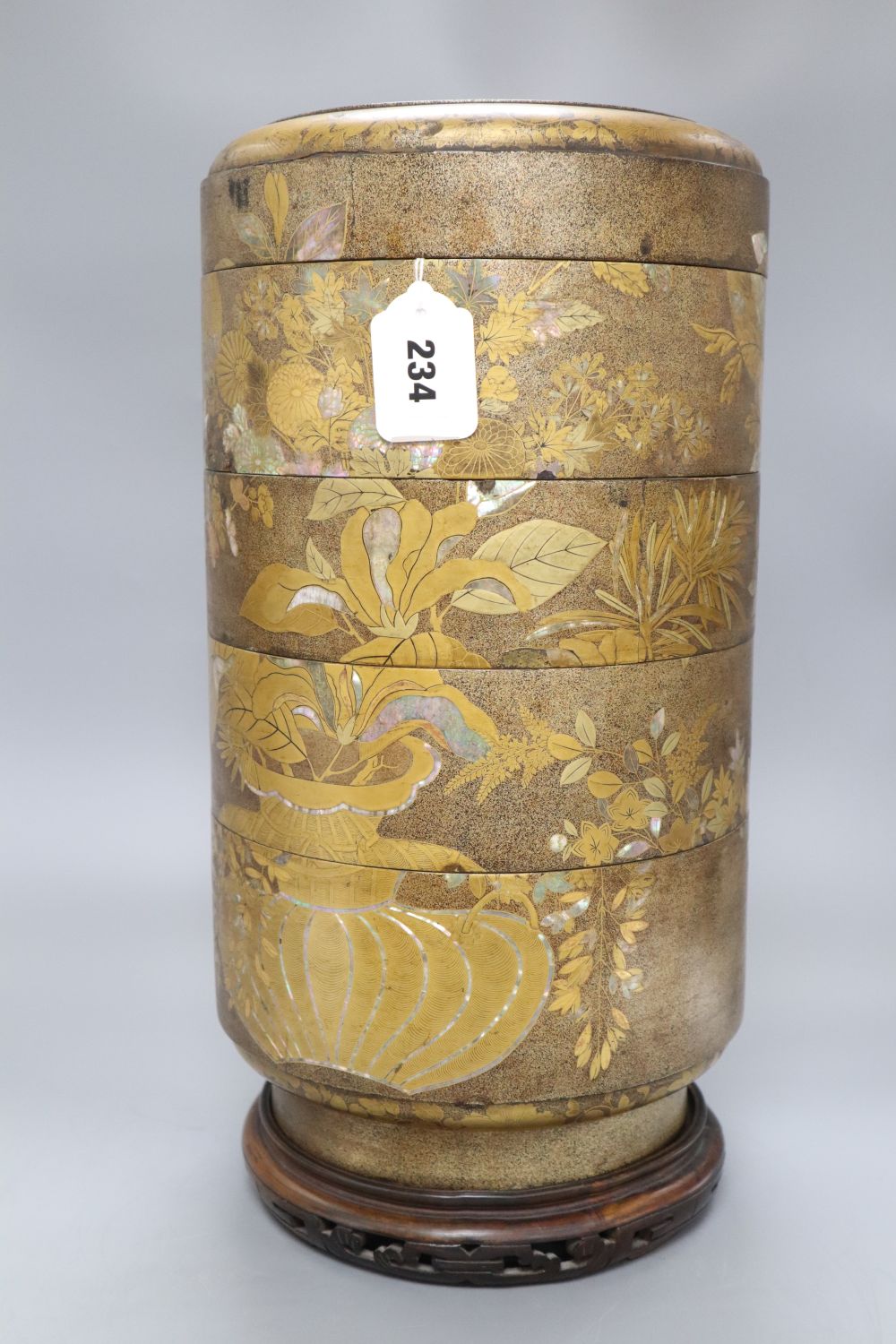 A 19th century Japanese sectional stack of mother of pearl and lacquered boxes, on hardwood stand, overall height 46cm